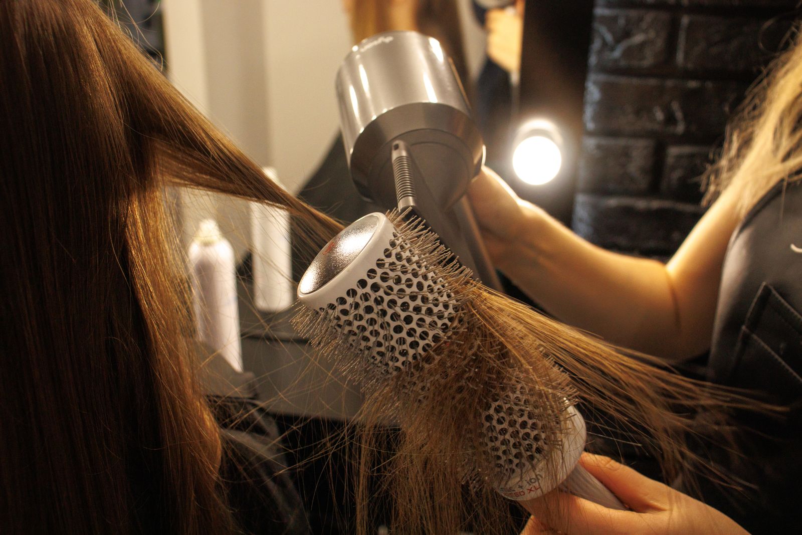 A round brush and dryer working through long hair