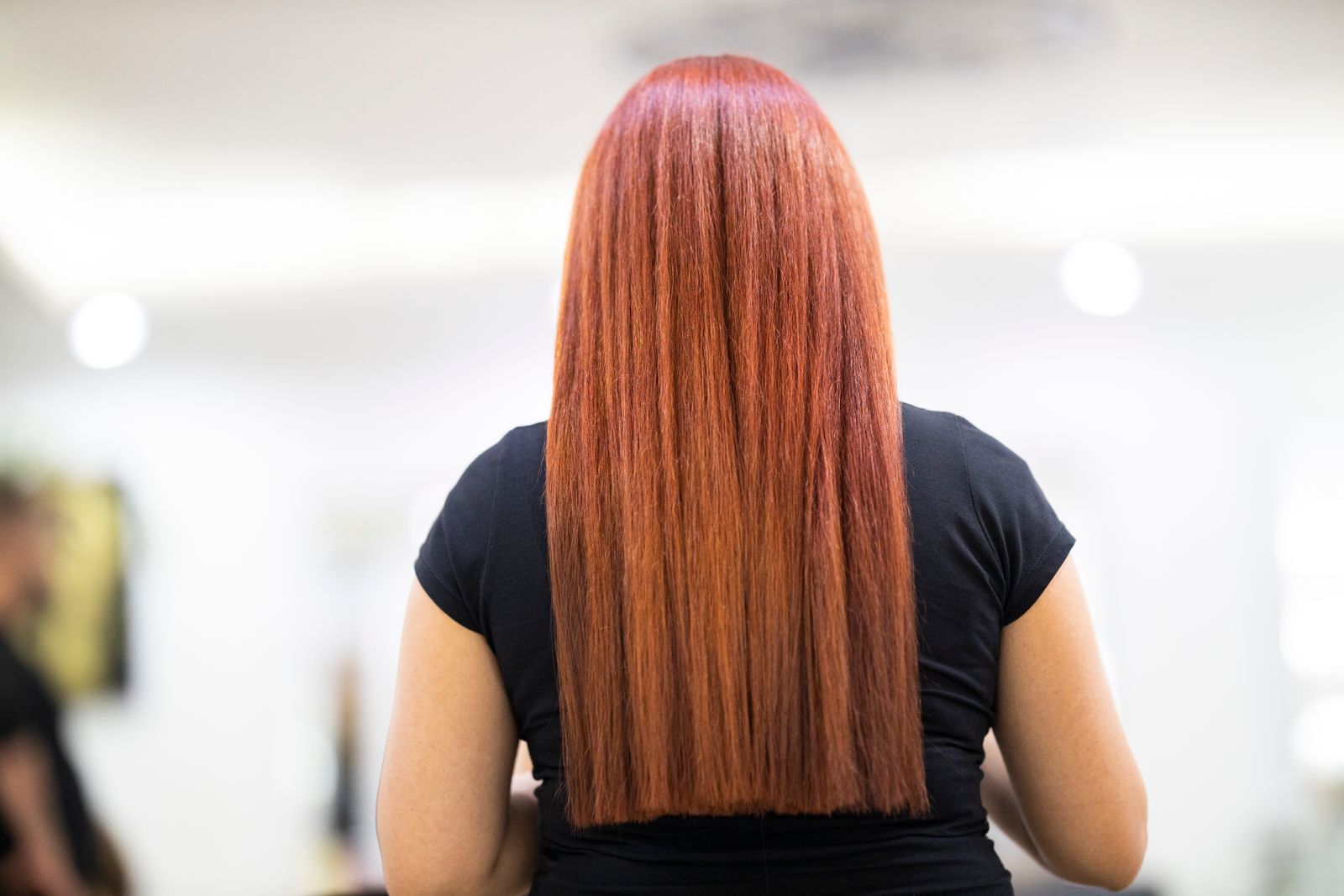 Long straight red hair falling smoothly down a client's back