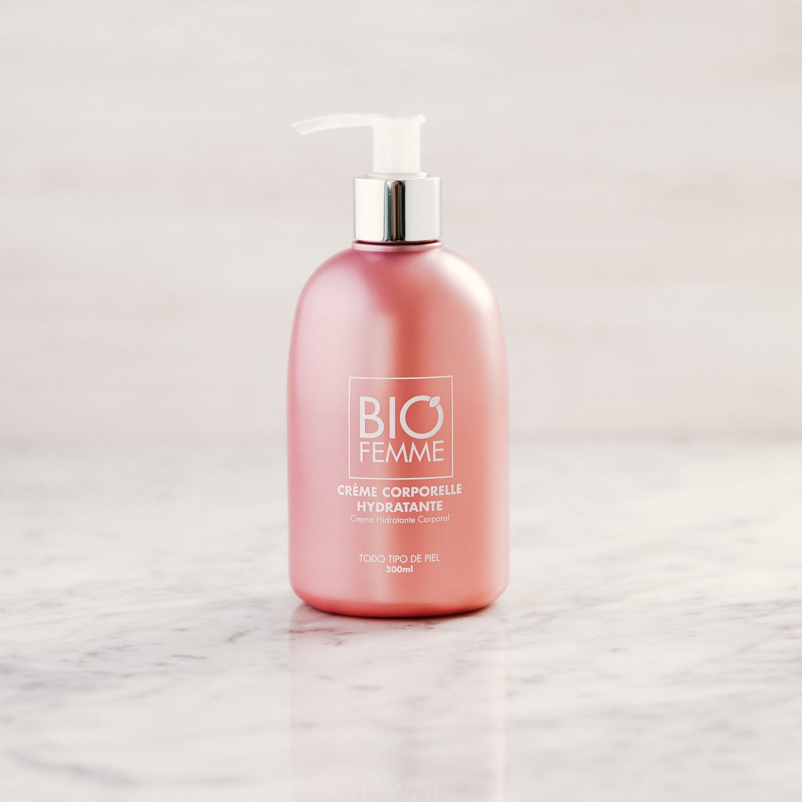 A pink pump bottle on a marble surface